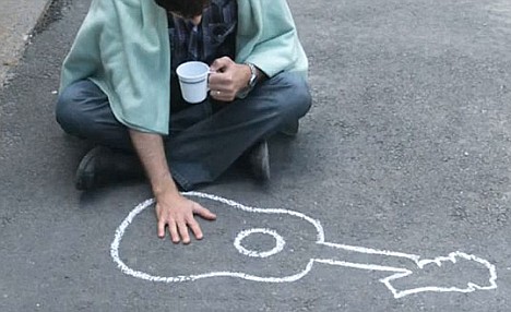 Dave-wrapped-in-a-blanket-and-cradling-a-coffee-cup,-pats-the-chalk-outline-of-his-shattered-guitar-as-police-investigate-the-incident-in-the-satirical-video